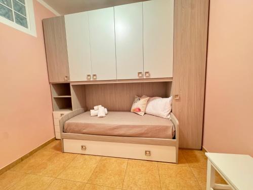 a small bedroom with a bed with white cabinets at A Casa di Mina in Ladispoli