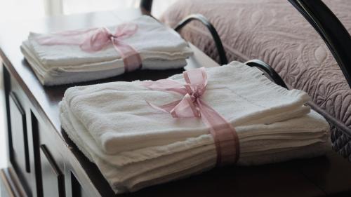 two folded towels with pink bows on a table at La dimora di Annarè in SantʼEufemia Lamezia