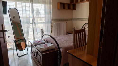 a small bedroom with a bed and a mirror at La dimora di Annarè in SantʼEufemia Lamezia