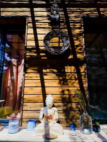 une statue assise sur une table devant un bâtiment dans l'établissement Grande villa 2 min plage - plein centre, à Vias