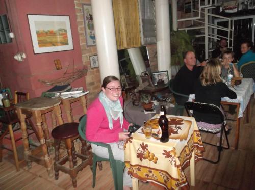 a woman sitting at a table in a restaurant at Le Karthala Chambres D'Hotes in Antananarivo