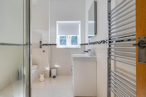a white bathroom with a sink and a toilet at River Fishing I Hot tub I Games Room I PetFriendly in Rainow