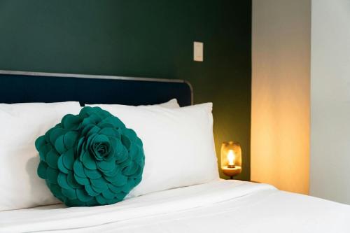 a green flower pillow on a white bed at Hotel Nell - Union Market in Washington