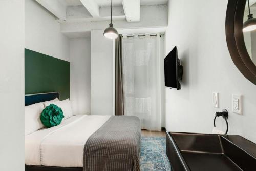 a bedroom with a bed and a sink and a tub at Hotel Nell - Union Market in Washington