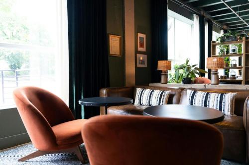 a waiting room with leather chairs and tables and a window at Hotel Nell - Union Market in Washington
