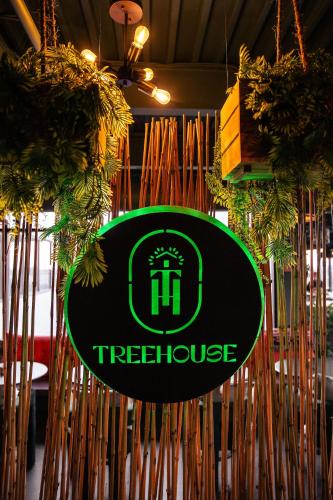 a treehouse sign hanging in a room with plants at Hotel Nell - Union Market in Washington