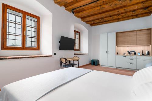 a bedroom with a white bed and a tv at Limehome Krems Undstraße in Krems an der Donau