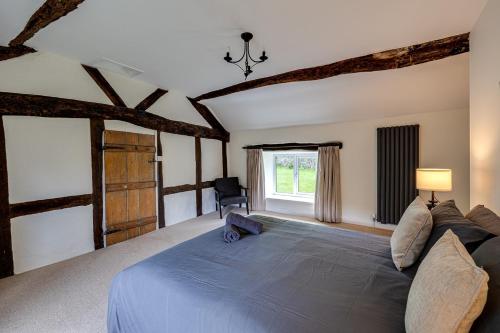 a bedroom with a large blue bed with a window at River Fishing I Hot tub I Games Room I PetFriendly in Rainow