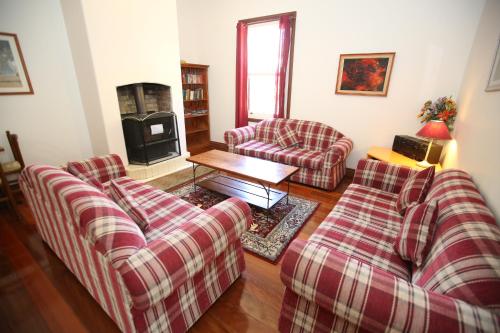 a living room with two couches and a fireplace at Belgravia Mountain Guest House in Katoomba