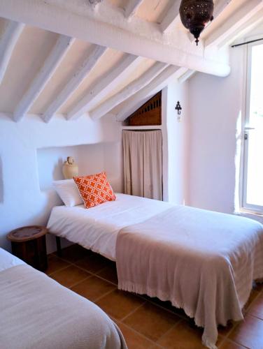 two beds in a room with white walls at Casa Miguel Montefrio in Granada