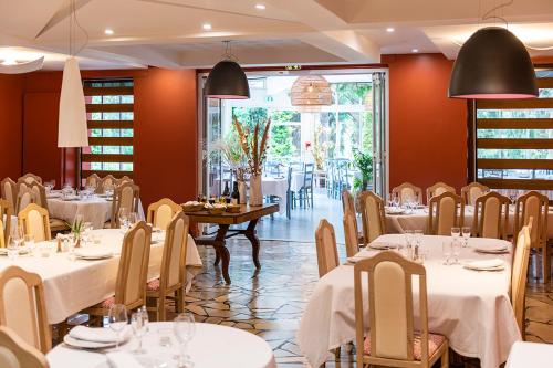 a dining room with white tables and chairs at Domaine La Gentilhommière in Satillieu