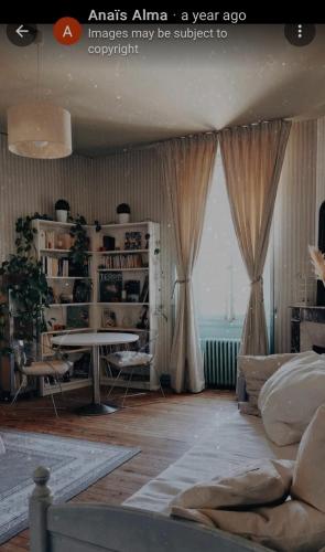 un salon avec un canapé, une table et une fenêtre dans l'établissement Abbey Road Le Thoureil, à Le Thoureil