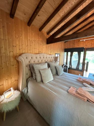 a bedroom with a bed in a room with wooden walls at Chalet Romantique in Marions