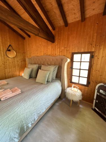 a bedroom with a bed in a wooden room at Chalet Romantique in Marions