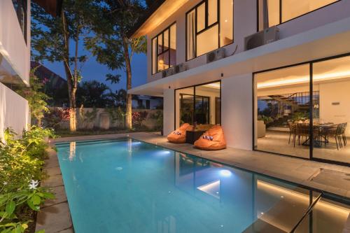 an image of a swimming pool in front of a house at Villa Daun 3 Canggu by Premier Hospitality Asia in Dalung