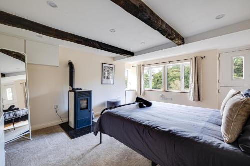 a bedroom with a bed and a wood stove at River Fishing I Hot tub I Games Room I PetFriendly in Rainow