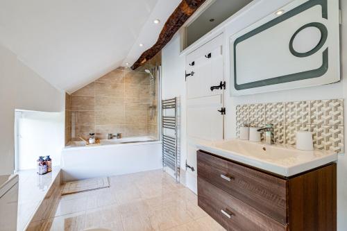 a bathroom with a sink and a tub and a shower at River Fishing I Hot tub I Games Room I PetFriendly in Rainow