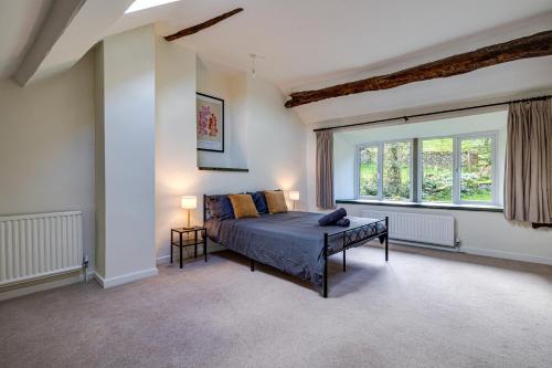 a bedroom with a bed and a large window at River Fishing I Hot tub I Games Room I PetFriendly in Rainow