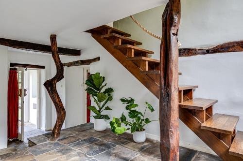 a living room with wooden stairs and plants at River Fishing I Hot tub I Games Room I PetFriendly in Rainow