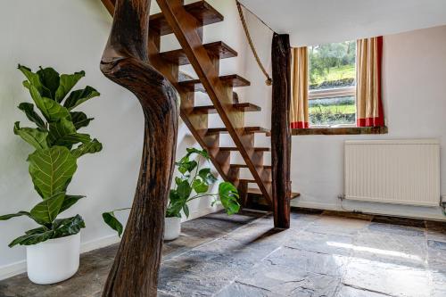 a wooden staircase in a room with plants at River Fishing I Hot tub I Games Room I PetFriendly in Rainow