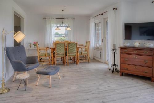 Una cocina y un comedor con mesa y sillas. en Landhaus Sonnenglück, en Tetenbüll
