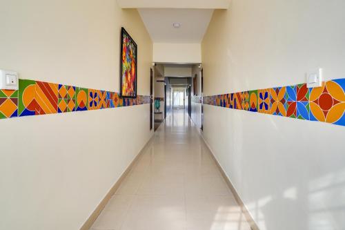 a hallway with colorful tile on the walls in a building at FabHotel VJR Electronic City in Bengaluru