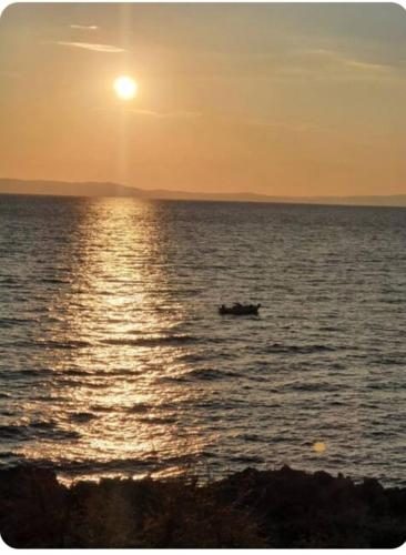 a boat in the middle of the ocean at sunset at Katafigio Holiday Homes in Riglia