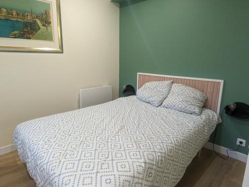 une chambre avec un lit avec une couette blanche dans l'établissement T2 à 15 minutes de Paris, à Gennevilliers