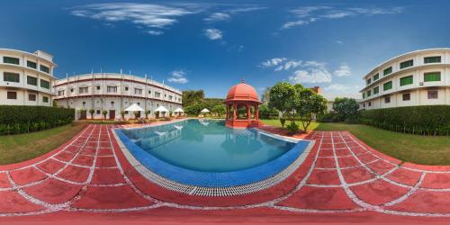 a resort with a swimming pool in front of two buildings at The Grand Imperial - Heritage Hotel in Agra