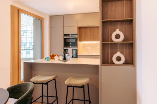 a kitchen with a counter and two stools at Media Bay Apartments in Kirchberg by Rentaroo in Luxembourg