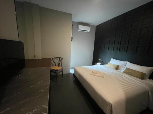 a bedroom with a large bed with a large headboard at 515 VICTORY Hotel in Pom Prap