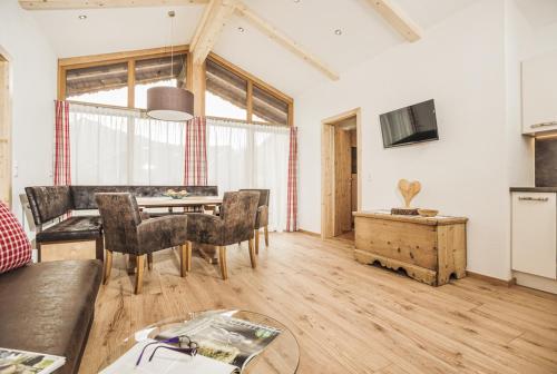 een woonkamer met een tafel en stoelen bij Farm Resort Geislerhof in Gerlos