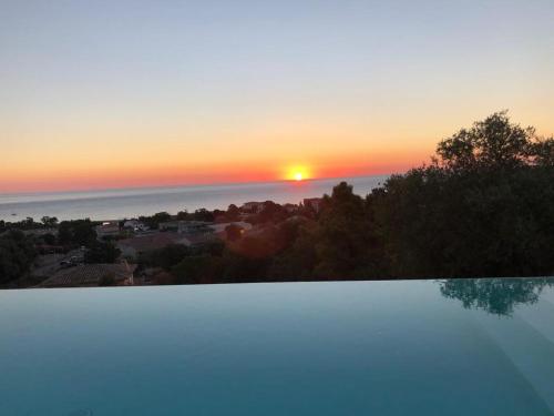 - une vue sur le coucher de soleil depuis la piscine dans l'établissement Maison Solenzara vue mer, à Sari-Solenzara