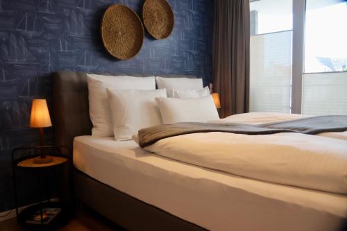a bedroom with a large bed with white pillows at Ferienwohnungen Momentum Norderney in Norderney