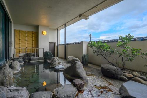 a room with rocks and a pond in a building at 竹屋ホテル in Tsuruoka