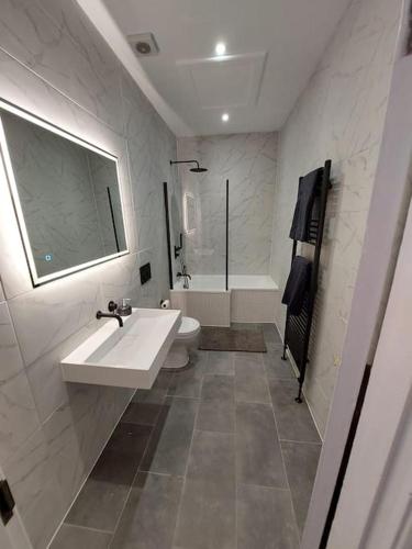 a white bathroom with a sink and a tub at Large newly refurbished house close to harbour Free Parking in Bristol