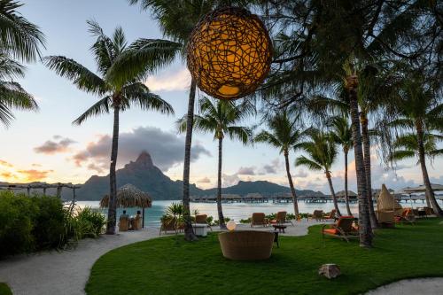 a lantern hanging from palm trees on the beach at InterContinental Bora Bora & Thalasso Spa by IHG in Bora Bora