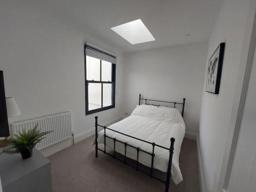 a white bedroom with a bed and a window at Large newly refurbished house close to harbour Free Parking in Bristol