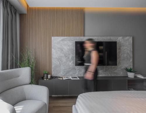 a woman standing in front of a tv in a room at Aristotelian Virtues - Sophia in Thessaloniki