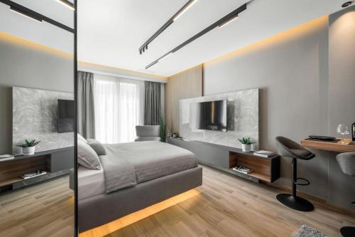 a bedroom with a bed and a desk and a television at Aristotelian Virtues - Sophia in Thessaloniki