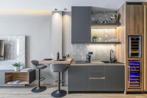 a kitchen with two bar stools and a sink at Aristotelian Virtues - Sophia in Thessaloniki