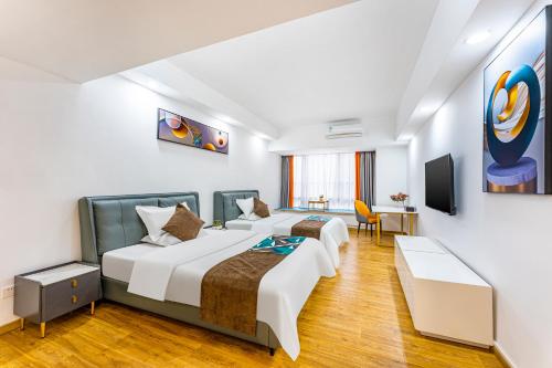a hotel room with two beds and a tv at Bene International Hotel Zhujiang New Town US Consulate General Guangzhou Branch in Guangzhou