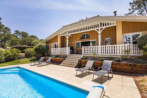 une maison avec une piscine devant une maison dans l'établissement villa piscine 4ch dans la pinede a 4min de l ocean AG1, à Lacanau
