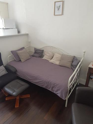 Una cama con sábanas moradas y una silla en una habitación en Maison d'hôtes du Faubourg Charrault Saint Maixent L'Ecole, en Saint-Martin-de-Saint-Maixent