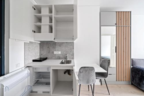 cocina con armarios blancos, escritorio y silla en Central Cozy 1Bedroom Apartment with Sofa Bed - Sleeps 4, en Vilna