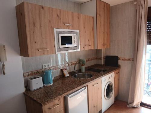a kitchen with a sink and a washing machine at weforyou Plza España Benalmádena in Benalmádena