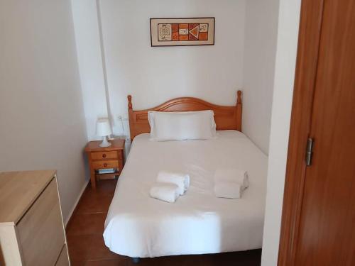a bedroom with a white bed with towels on it at weforyou Plza España Benalmádena in Benalmádena