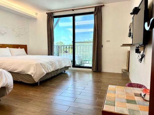 a hotel room with a bed and a large window at Nanwan254 Homestay in Nanwan