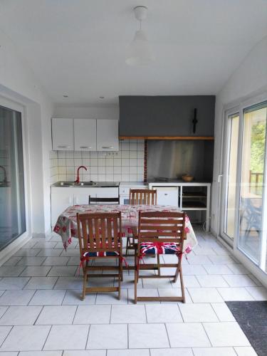 une cuisine avec une table et des chaises dans une pièce dans l'établissement Villa Castellane, à Castellane