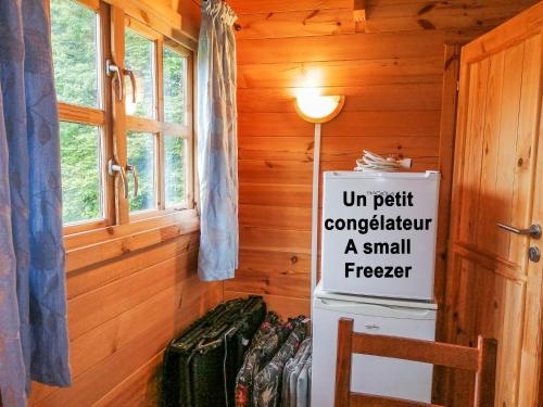 a sign in a room with a small freezer at Le Chalet De Louyère in Saint-Salvadour